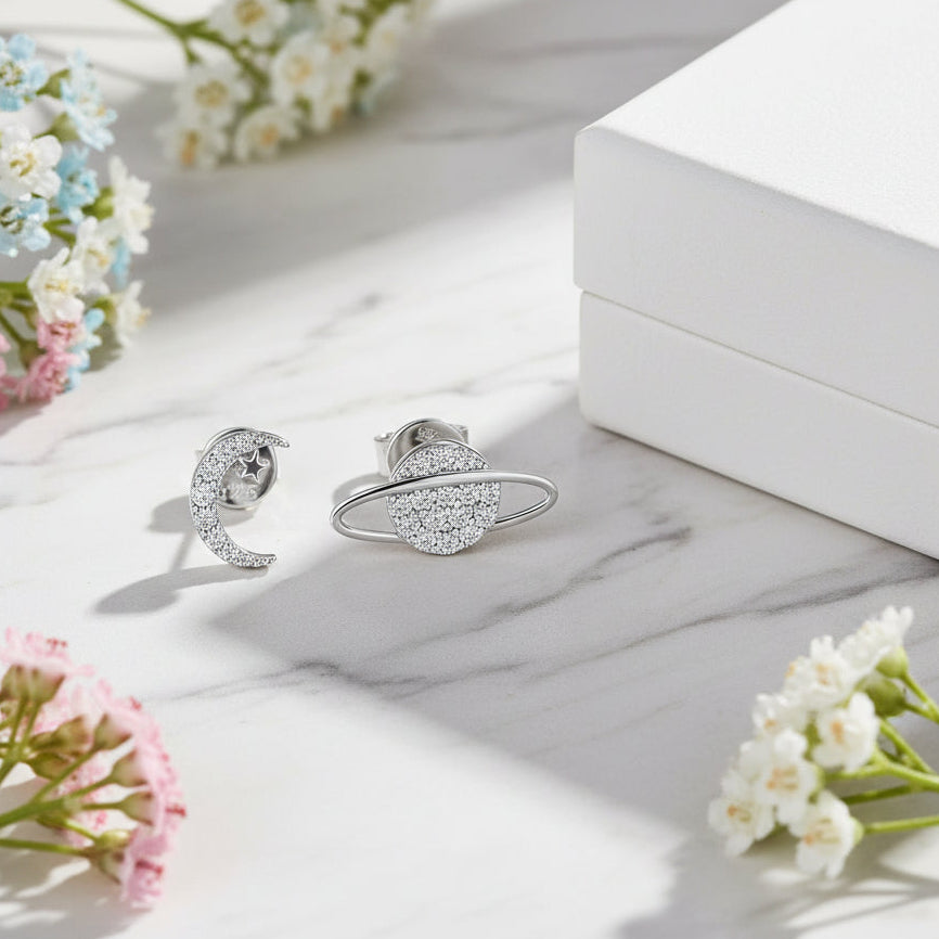 Moon & Saturn Micro Inlaid Moissanite Earrings set in 925 Sterling Silver (GRA) Capella Reya next to box